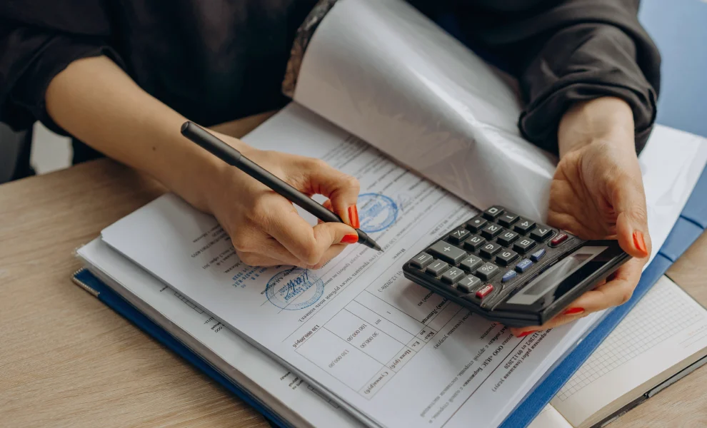 Close-up of hands managing financial records and bookkeeping tools
